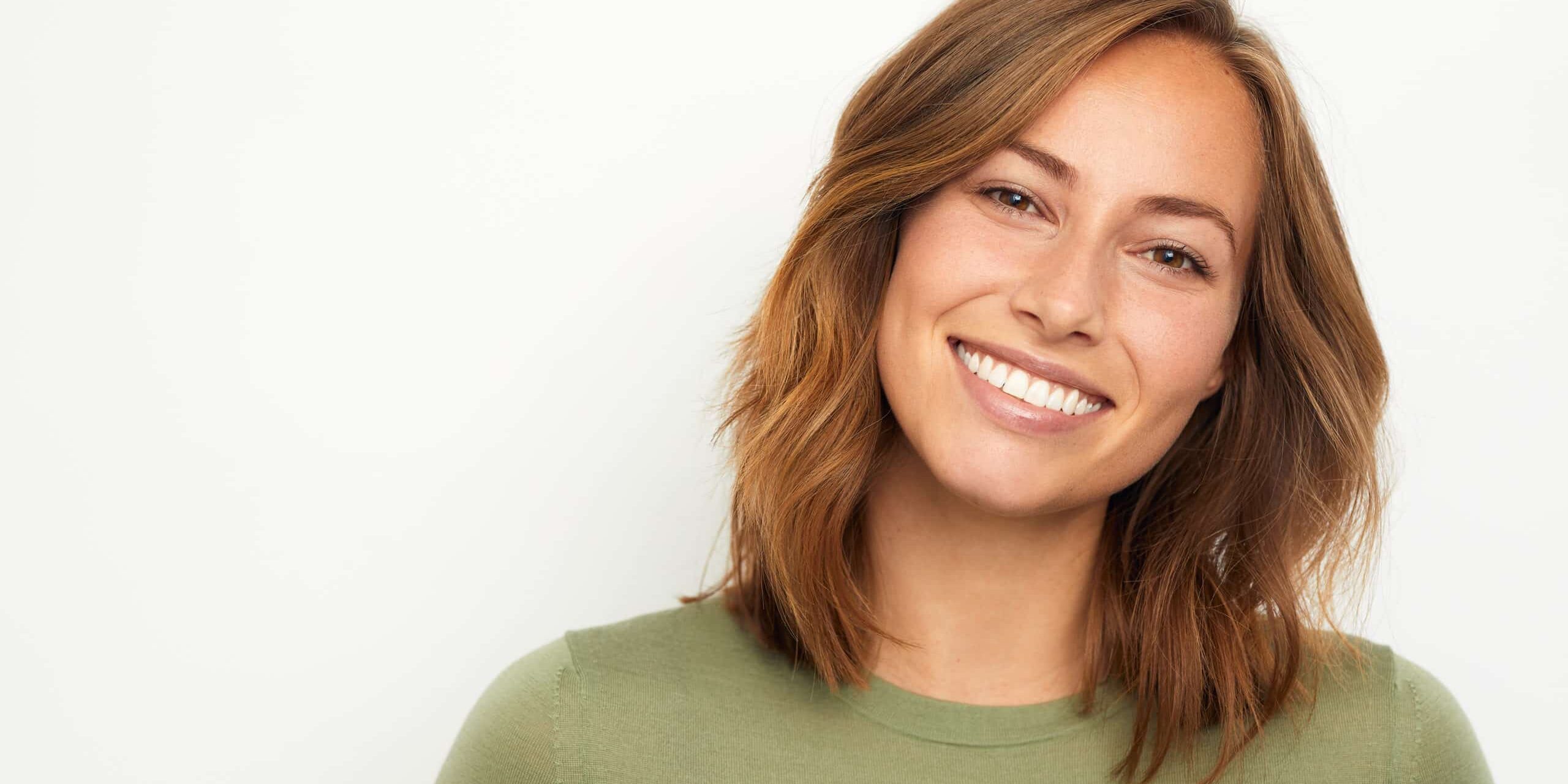 portrait of a young happy woman smiling on white background
